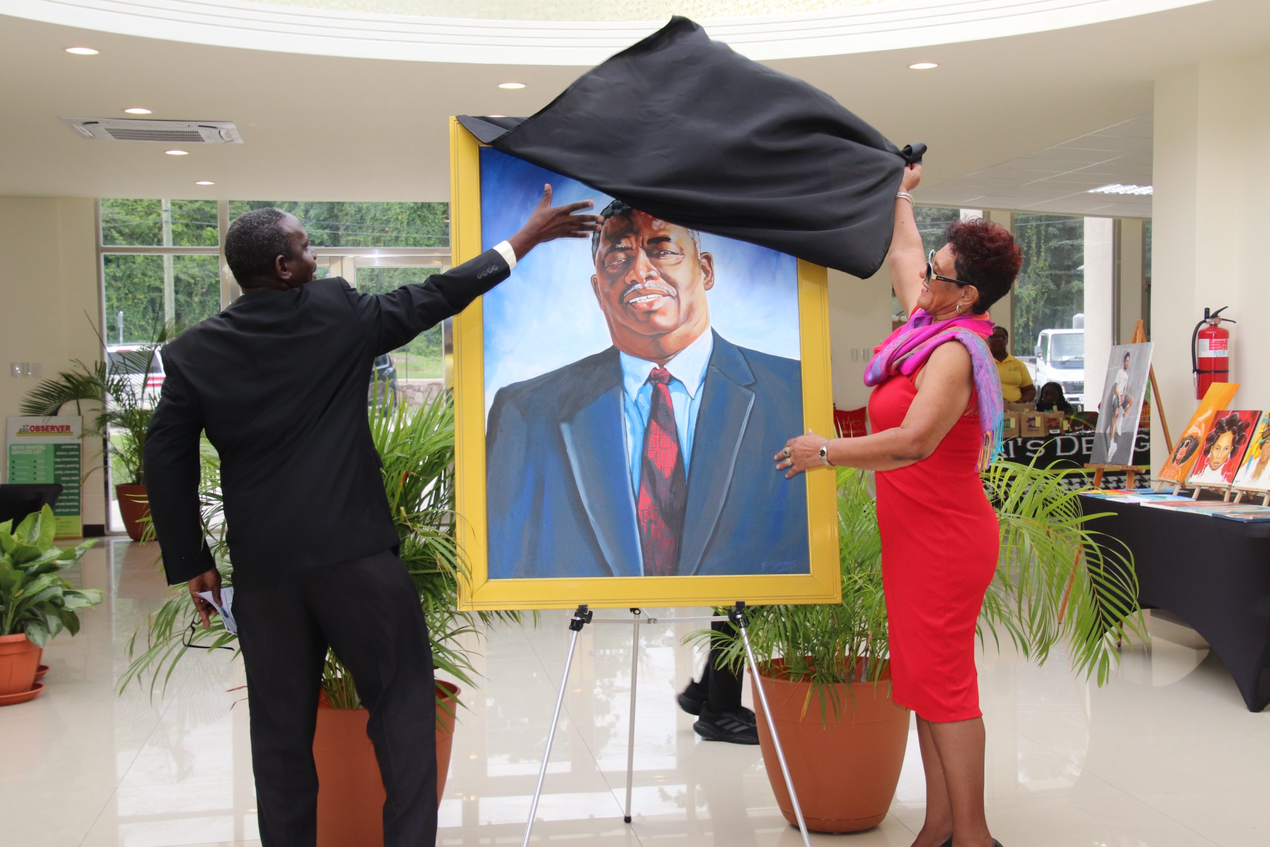 (L-r) Mr. John Hanley, Permanent Secretary in the Ministry of Tourism on Nevis, assisting Mrs. Yvonne Guishard, widow of the late Hon. Malcolm Guishard, former Deputy Premier of Nevis and Minister of Tourism, patron of the Malcolm Guishard Recreational Park, with the unveiling of his portrait on his birthdate on January 16, 2023, at the Visitor Centre